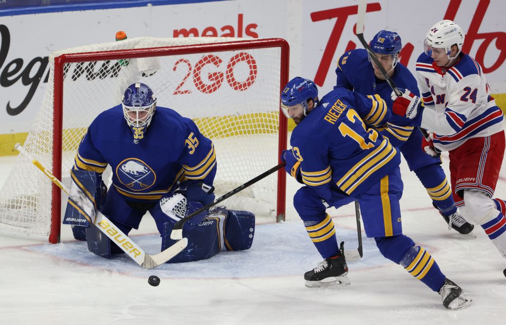 Buffalo Sabres goaltender Linus Ullmark (35) makes a save as center Tobias Rieder (13) moves to clear the puck.